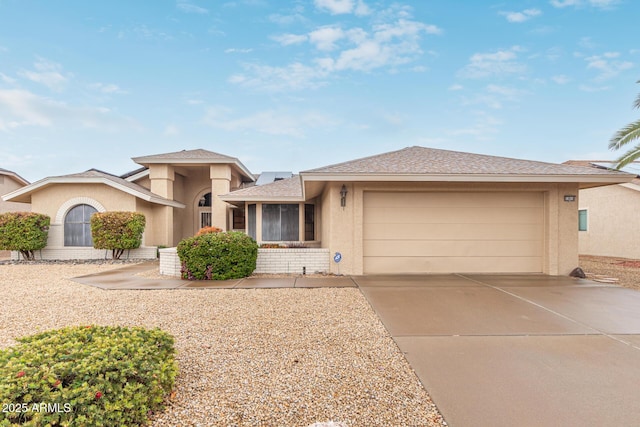 view of front of property featuring an attached garage, driveway, and stucco siding