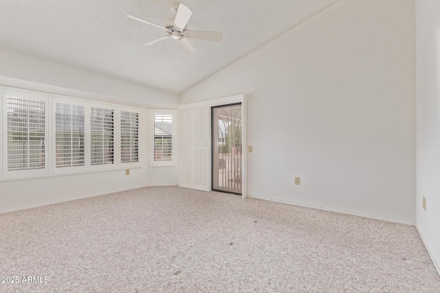 spare room with ceiling fan, lofted ceiling, carpet, and a textured ceiling