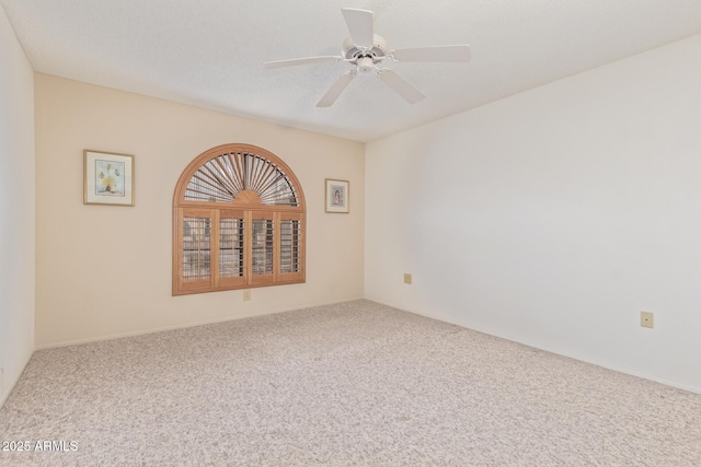 carpeted empty room featuring a textured ceiling and a ceiling fan