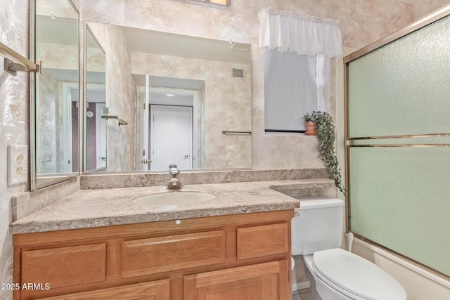 bathroom featuring visible vents, toilet, vanity, and wallpapered walls