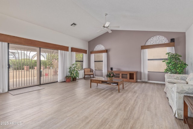 living area with a ceiling fan, visible vents, baseboards, lofted ceiling, and light wood-style floors