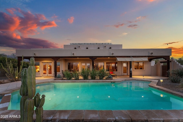 pool at dusk featuring a patio area