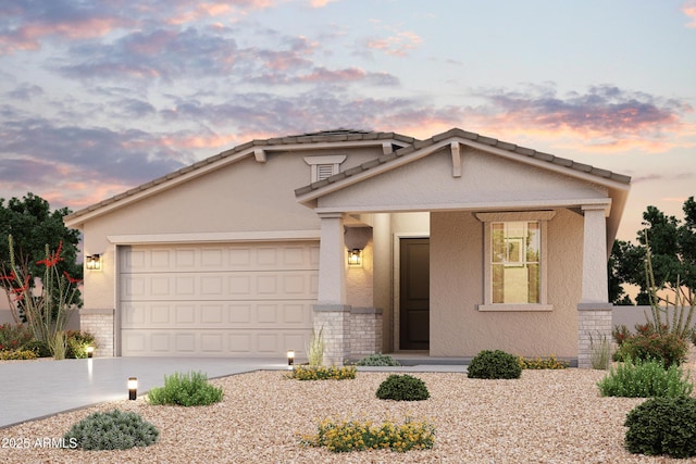 view of front of home with brick siding, stucco siding, driveway, and an attached garage