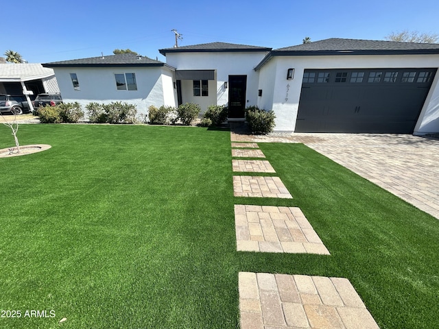 view of front of house with a garage, stucco siding, driveway, and a front lawn