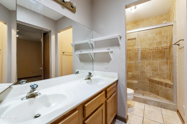 bathroom featuring tile patterned flooring, a shower stall, toilet, and a sink