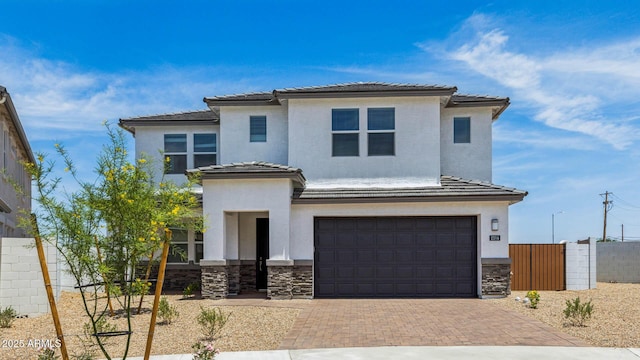 2316 W Moody Trl, Phoenix, AZ 85041 - view of front facade featuring a garage, decorative driveway, stone siding, stucco siding, and a tile roof