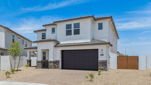 2316 W Moody Trl, Phoenix, AZ 85041 - view of front of house featuring a tile roof, stone siding, a garage, and decorative driveway