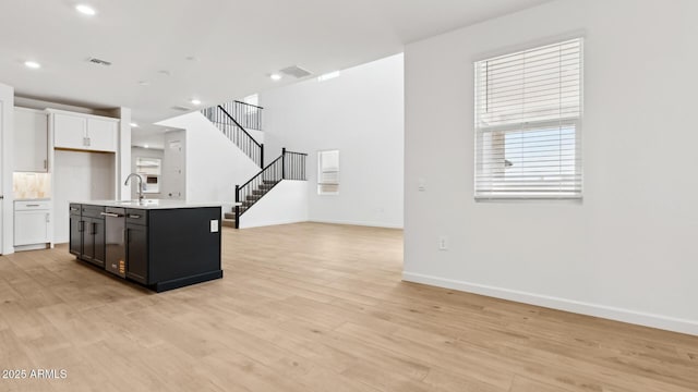 2316 W Moody Trl, Phoenix, AZ 85041 - kitchen featuring light countertops, open floor plan, baseboards, light wood-style flooring, and stainless steel dishwasher