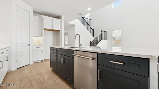 2316 W Moody Trl, Phoenix, AZ 85041 - kitchen featuring dishwasher, a sink, white cabinetry, light wood-style flooring, and light countertops