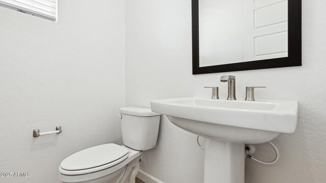 2316 W Moody Trl, Phoenix, AZ 85041 - half bath featuring toilet, baseboards, and a sink