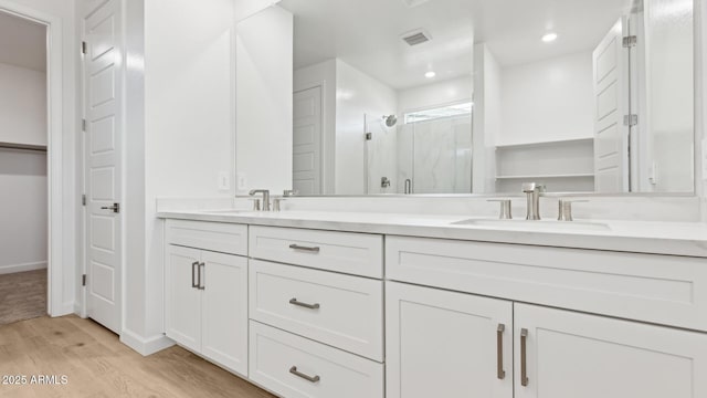 2316 W Moody Trl, Phoenix, AZ 85041 - bathroom featuring double vanity, a stall shower, wood finished floors, baseboards, and recessed lighting