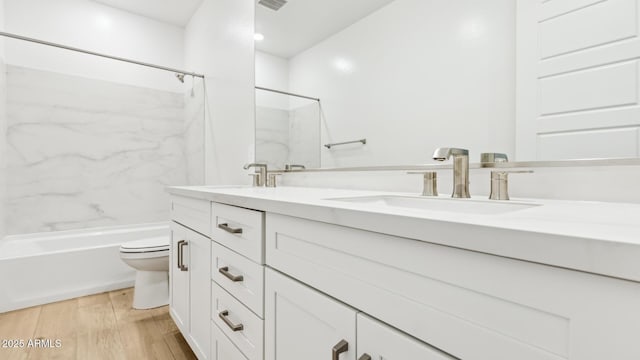 2316 W Moody Trl, Phoenix, AZ 85041 - full bath with double vanity, toilet, a combined bath / shower with marble appearance, and wood finished floors