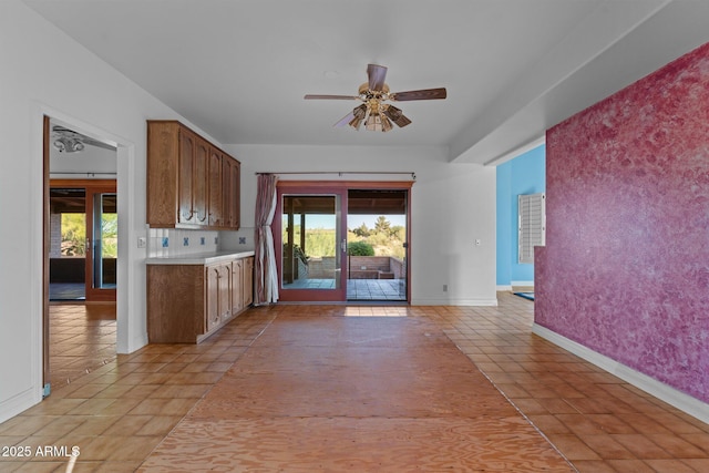 1503 N Thrasher Ln, Wickenburg, AZ 85390 - kitchen with light countertops, ceiling fan, light tile patterned floors, and brown cabinetry