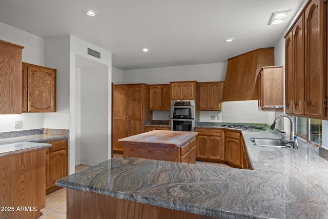 1503 N Thrasher Ln, Wickenburg, AZ 85390 - kitchen featuring stainless steel appliances, brown cabinetry, a kitchen island, recessed lighting, and dark stone countertops