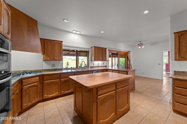 1503 N Thrasher Ln, Wickenburg, AZ 85390 - kitchen with stainless steel appliances, brown cabinetry, a kitchen island, a ceiling fan, and recessed lighting