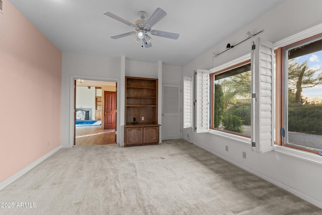1503 N Thrasher Ln, Wickenburg, AZ 85390 - unfurnished living room with light colored carpet and a ceiling fan