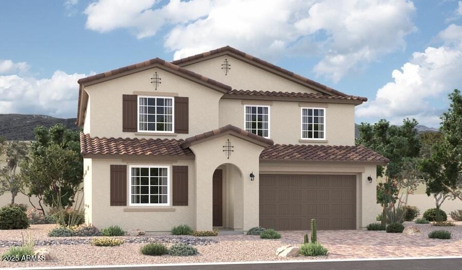 mediterranean / spanish-style house featuring driveway, a tiled roof, an attached garage, and stucco siding