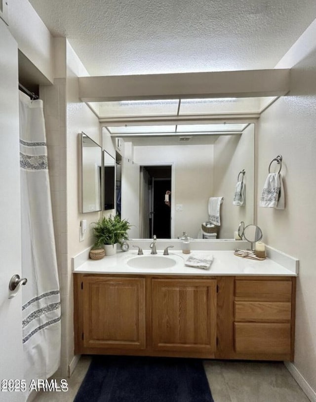 full bath featuring a textured ceiling and vanity