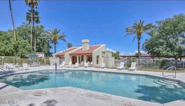 pool with a patio area and fence