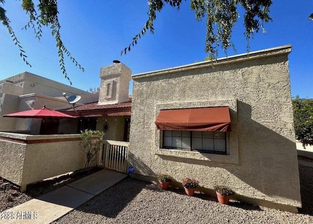 rear view of house featuring stucco siding