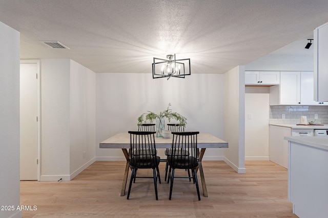 4740 E Portland St, Phoenix, AZ 85008 - dining space featuring baseboards, an inviting chandelier, visible vents, and light wood-type flooring