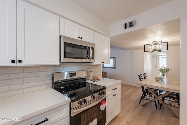 4740 E Portland St, Phoenix, AZ 85008 - kitchen featuring light countertops, visible vents, light wood-type flooring, tasteful backsplash, and appliances with stainless steel finishes