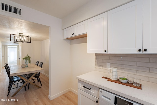 4740 E Portland St, Phoenix, AZ 85008 - kitchen with visible vents, baseboards, decorative backsplash, a chandelier, and light wood-style flooring