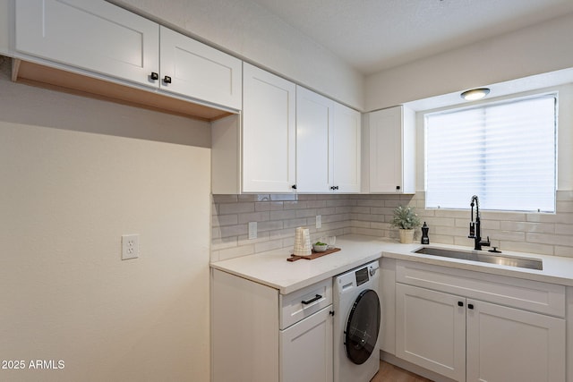 4740 E Portland St, Phoenix, AZ 85008 - kitchen with a sink, decorative backsplash, washer / dryer, light countertops, and white cabinetry