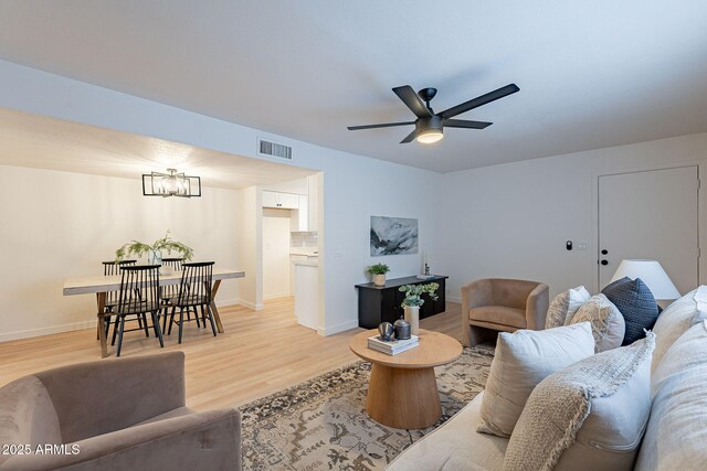 4740 E Portland St, Phoenix, AZ 85008 - living area featuring baseboards, light wood-style floors, visible vents, and ceiling fan with notable chandelier