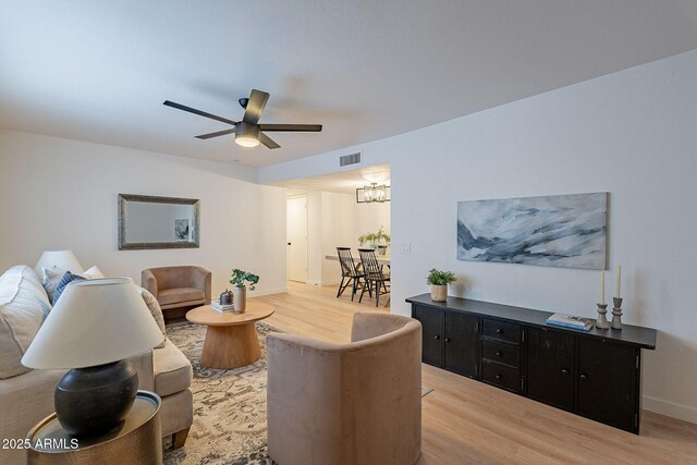 4740 E Portland St, Phoenix, AZ 85008 - living area with baseboards, wood finished floors, visible vents, and ceiling fan with notable chandelier