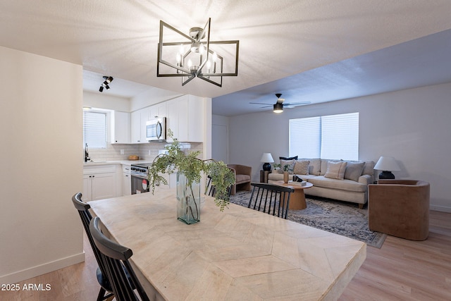 4740 E Portland St, Phoenix, AZ 85008 - dining space featuring light wood-type flooring, baseboards, and ceiling fan with notable chandelier