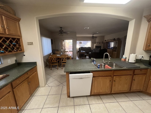 kitchen with light tile patterned flooring, sink, dishwasher, kitchen peninsula, and ceiling fan