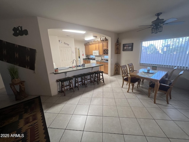 dining space with light tile patterned floors and ceiling fan