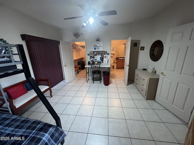 tiled bedroom with a walk in closet and ceiling fan