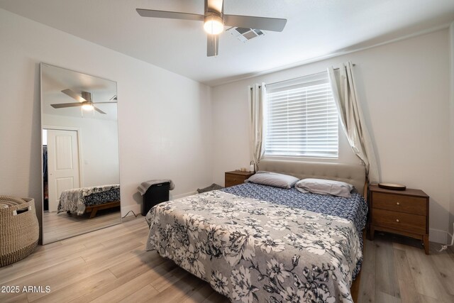 bedroom featuring light wood-style floors, visible vents, and ceiling fan