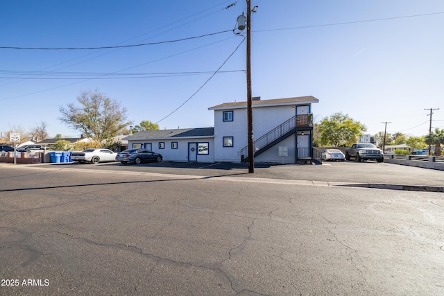 view of front of house featuring uncovered parking and stairway