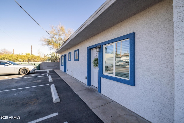 view of property exterior with uncovered parking and stucco siding