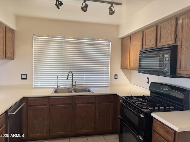 kitchen with black appliances, track lighting, a sink, and light countertops