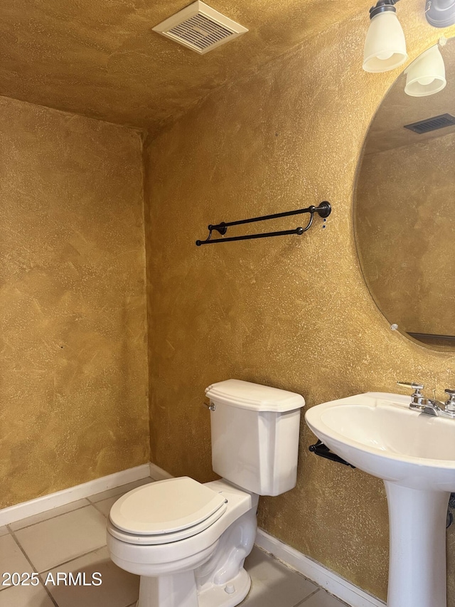 half bathroom featuring visible vents, toilet, tile patterned flooring, and baseboards