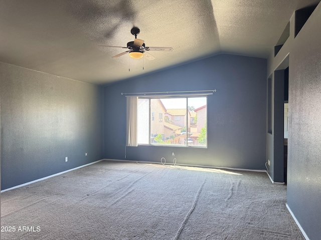 spare room featuring a textured ceiling, ceiling fan, vaulted ceiling, and carpet