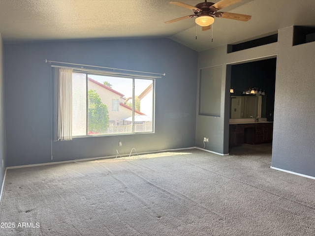 carpeted spare room featuring baseboards, a ceiling fan, a textured ceiling, and lofted ceiling