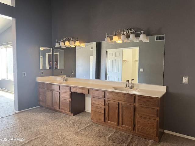 bathroom with double vanity, visible vents, baseboards, and a sink