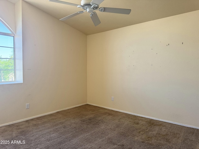 carpeted spare room featuring baseboards, a ceiling fan, lofted ceiling, and plenty of natural light