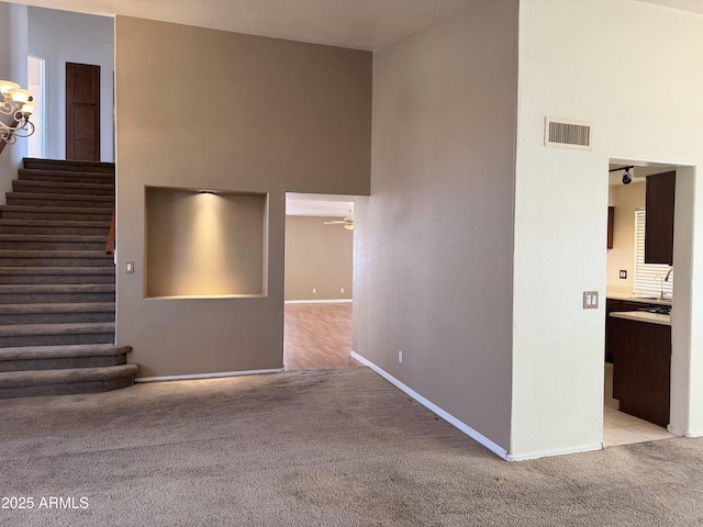 interior space with visible vents, ceiling fan, carpet floors, and baseboards