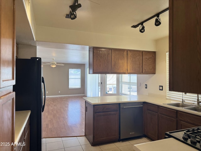 kitchen featuring a sink, ceiling fan, freestanding refrigerator, dishwasher, and rail lighting