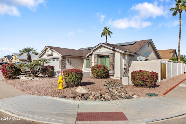 single story home featuring a garage and solar panels