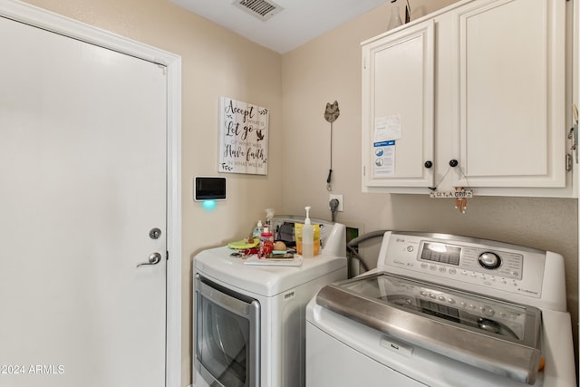 laundry room featuring cabinets and washing machine and dryer