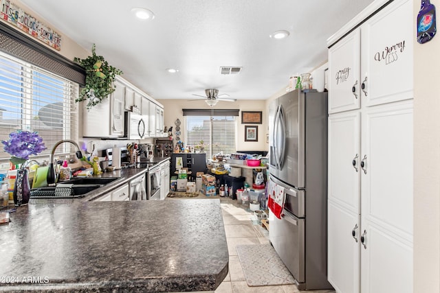 kitchen with sink, white cabinetry, stainless steel appliances, and a wealth of natural light