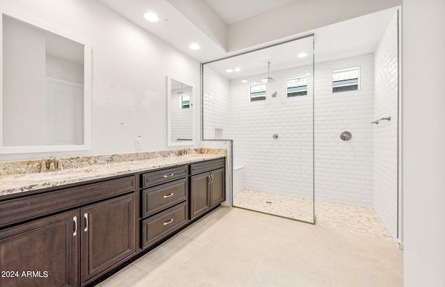 bathroom with vanity, tile patterned flooring, and tiled shower