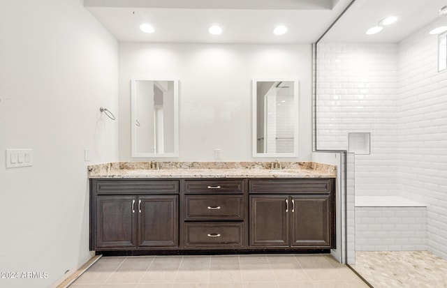 bathroom featuring vanity, tile patterned floors, and tiled shower